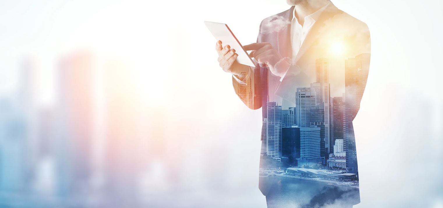 Professional holding a tablet with a double-exposure city skyline overlay